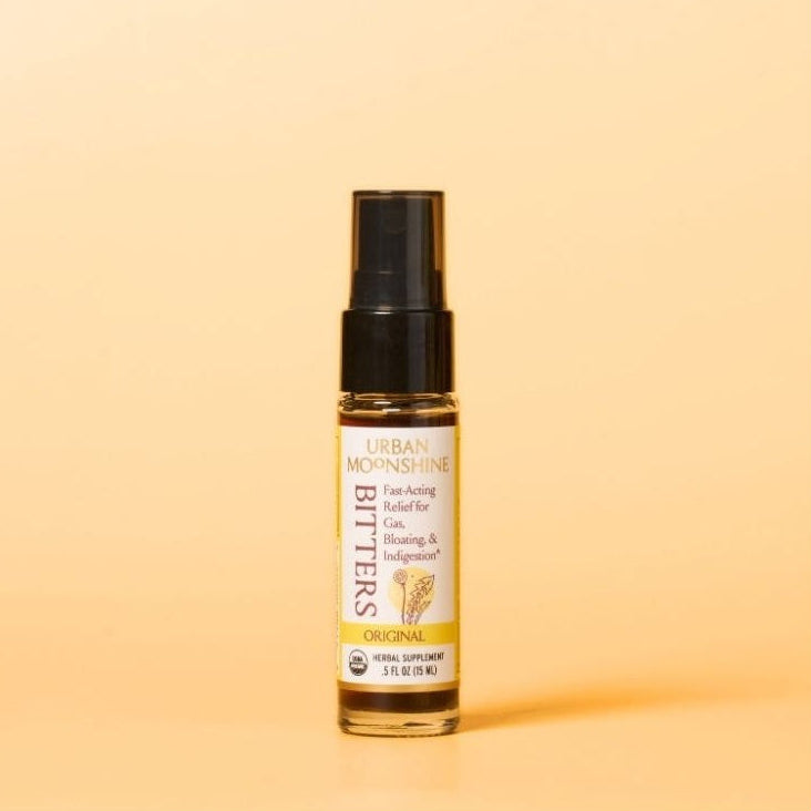 Bottle of Urban Moonshine Bitters on a light orange background