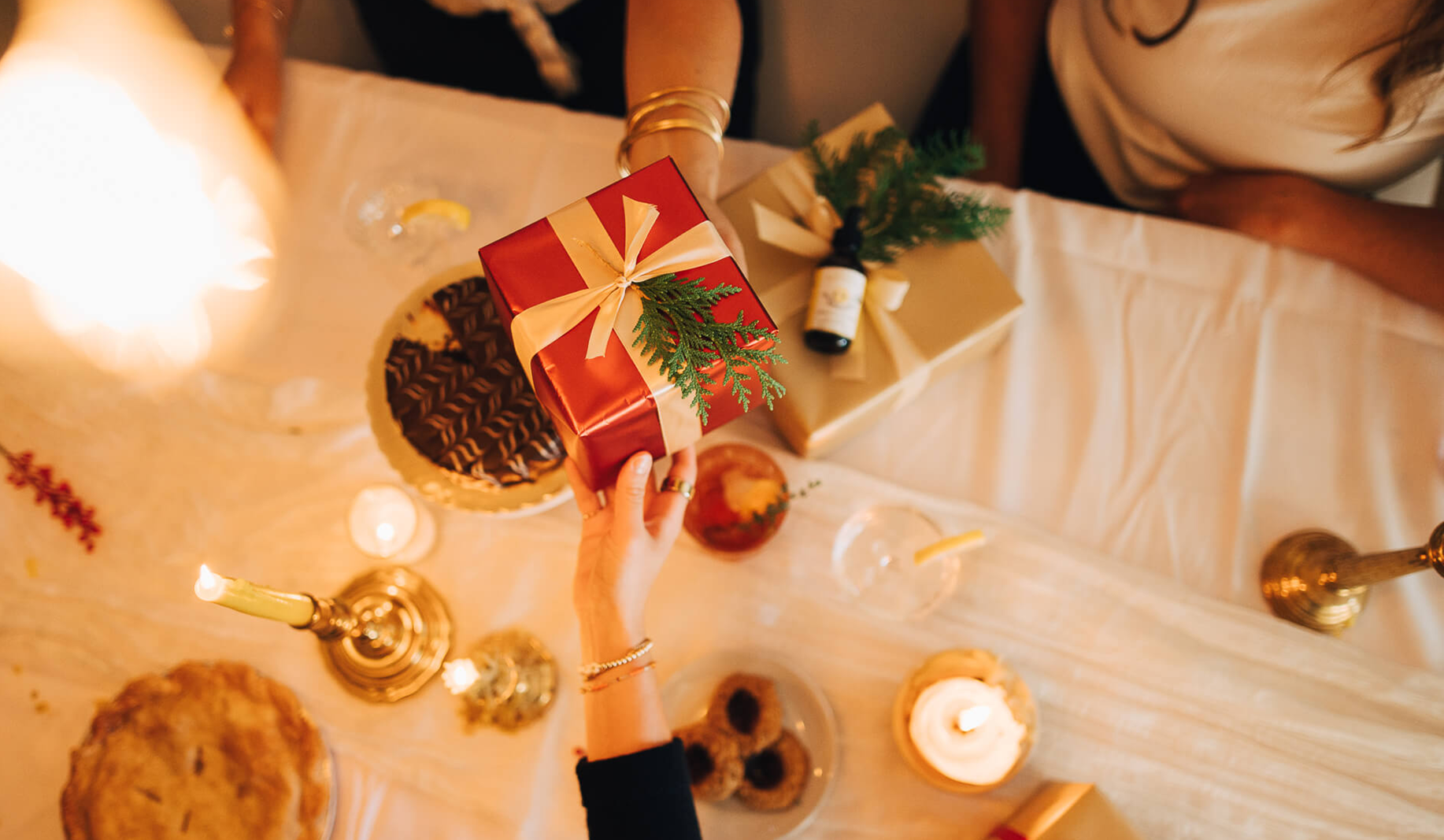 Hands giving gift over tablescape