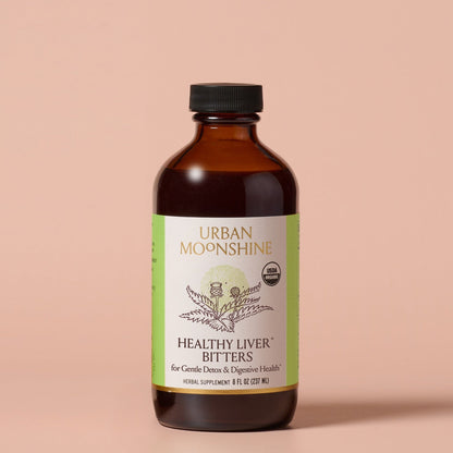 Bottle of Urban Moonshine Healthy Liver Bitters on a beige background