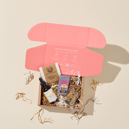 Gift box with products and a pink boxon a beige background